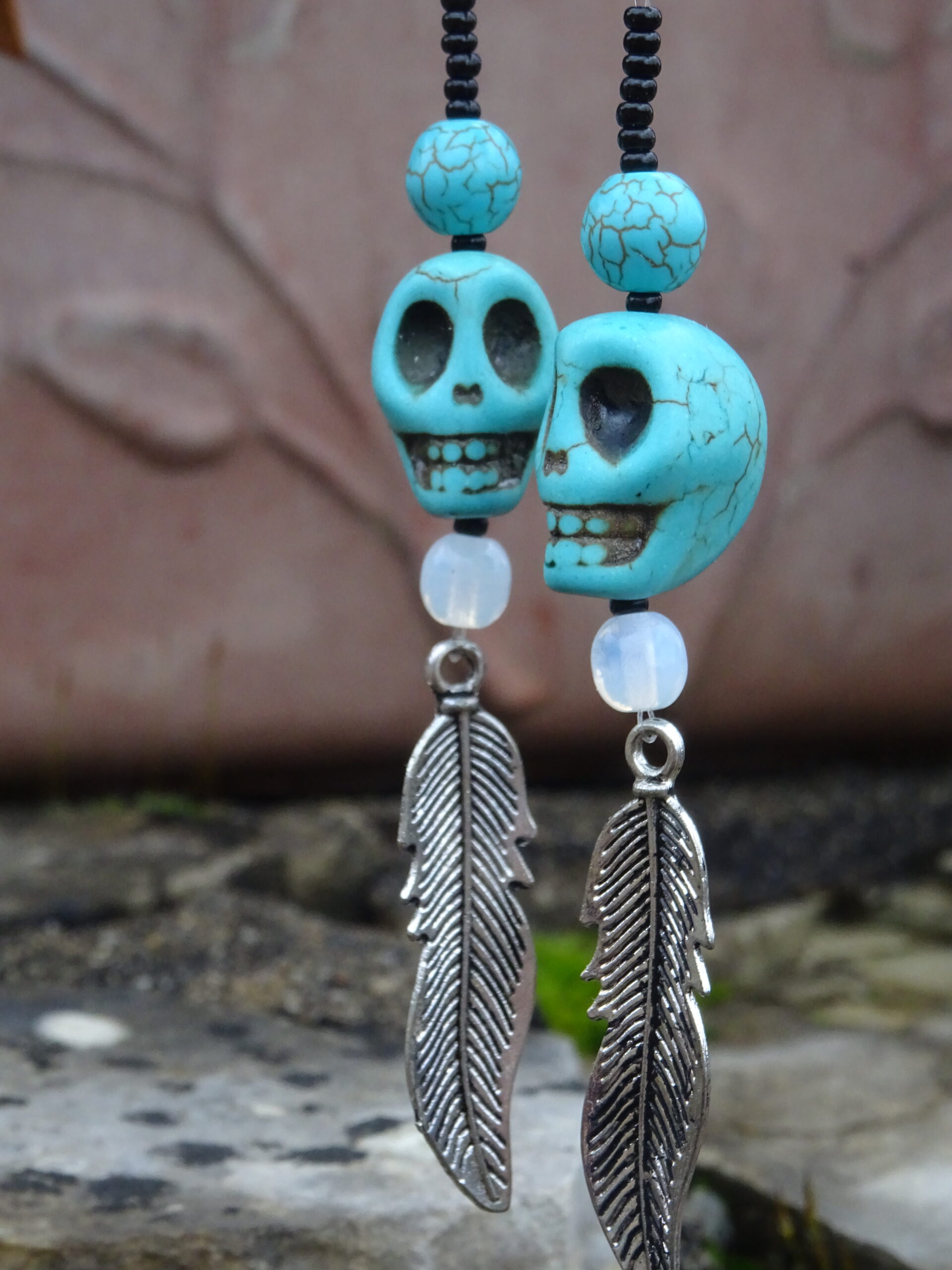 boucles d'oreille tête de mort en pierre turquoise et plume